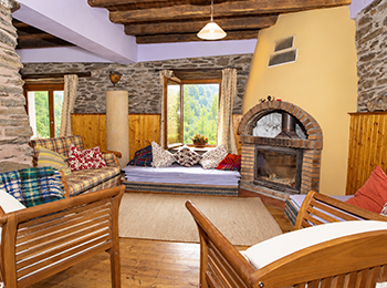 Salón de Mokorreko Borda, con piedra, madera y chimenea